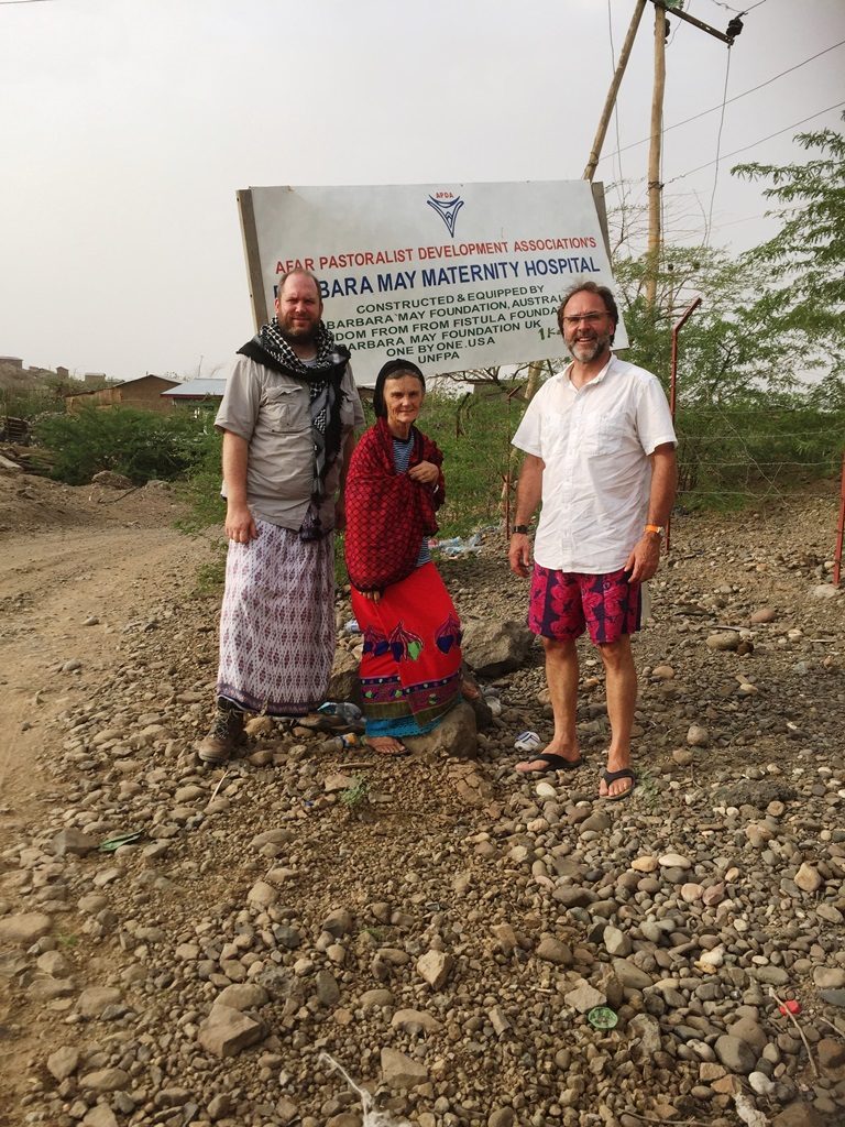 CGA Team members Jason Kelly and Warren Creates pose with APDA's Valerie Browning outside the road to the Barbar May Maternity Hospital